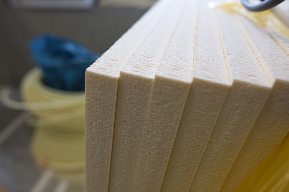 Ein Stapel cremefarbener Dämmplatten aus Hartschaum in der Nahaufnahme.